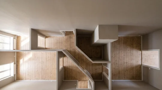 Wide overhead view of an empty residential interior with an awkward layout, long corridor and natural light crossing the floor